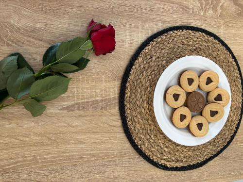 - un bol de biscuits sur une table à côté d'une rose dans l'établissement Élixir, à Villeurbanne