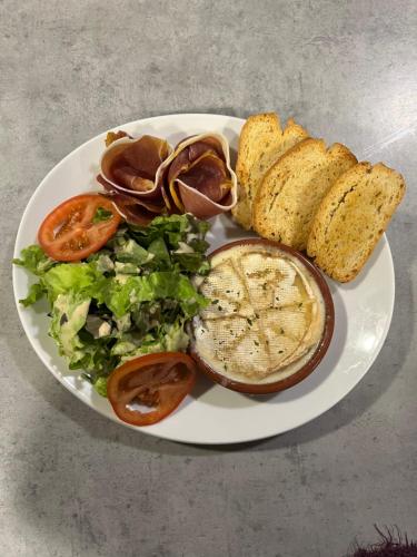 a white plate of food with a salad and bread at Logis Hôtel restaurant des Voyageurs in Saint-Paulien