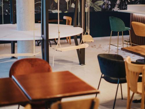 a group of tables and chairs in a room at Greet Hotel Brest Aéroport in Guipavas
