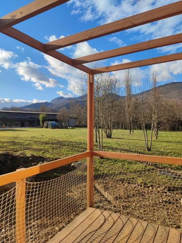a wooden deck with a view of a field at Tiny House au pied de Vercors in La Motte-Fanjas