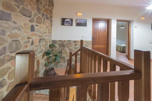 a staircase in a house with a stone wall at Casa Rural La Fuente in Segura de León