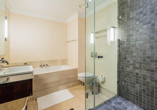 a bathroom with a shower and a toilet and a sink at Mandela Rhodes Place in Cape Town in Cape Town