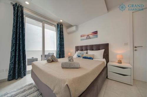 a bedroom with a large bed and a large window at Modern Oasis Luxe with BigYard in San Ġwann