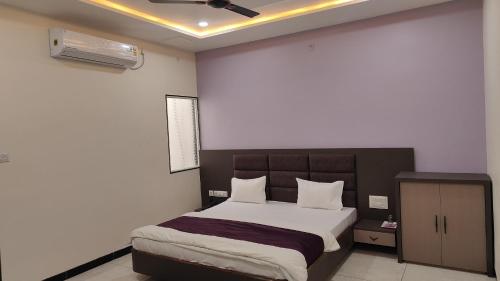 a bedroom with a large bed with white sheets at Yashomati Hotel in Maheshwar