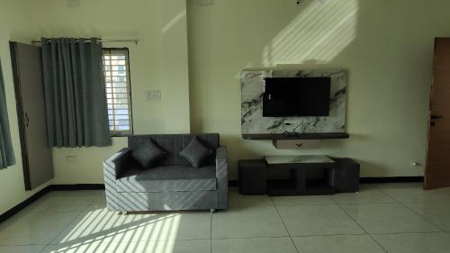 a living room with a chair and a television at Yashomati Hotel in Maheshwar
