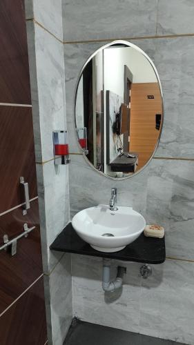 a bathroom with a sink and a mirror at Yashomati Hotel in Maheshwar