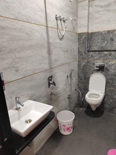 a bathroom with a sink and a toilet at Yashomati Hotel in Maheshwar