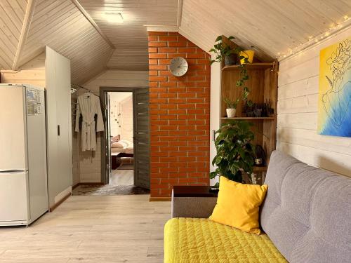 a living room with a couch and a brick wall at Три-О Апартаменти з видом на гори, максимум для 4 гостей, 15 хв від центру in Slavske