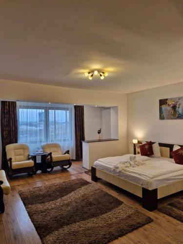 a bedroom with a bed and a table and chairs at Pensiunea Denim in Şelimbăr