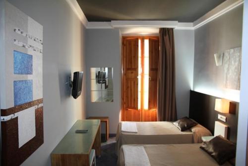 Habitación de hotel con cama, sofá y mesa en Hostal Plaza Ruiz, en Ceuta