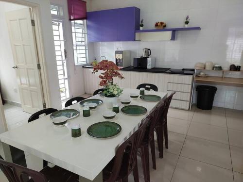 eine Küche mit einem Tisch und grünen Platten darauf in der Unterkunft Desaru Recreation House Billiard-Netflix-Dart-BBQ in Bandar Penawar