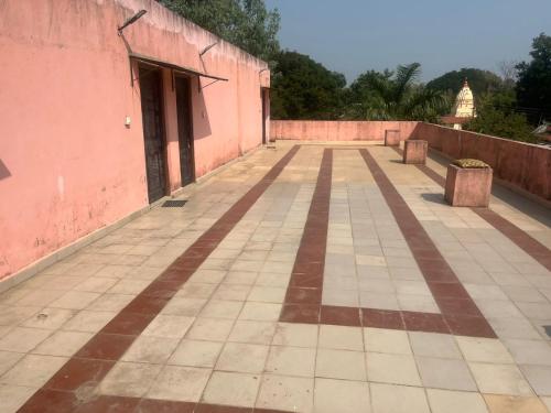 an empty courtyard of a pink building with a doorway at Sandeep's Homestay in Mohurli