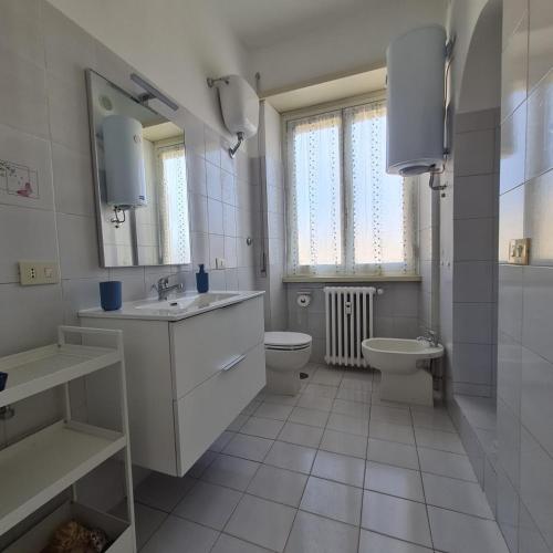 a white bathroom with a toilet and a sink at L' attichetto in Rome