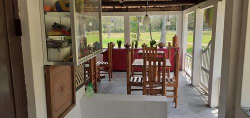 a dining room with a red table and chairs at Arachiwil Green Nature Resort in Puttalam