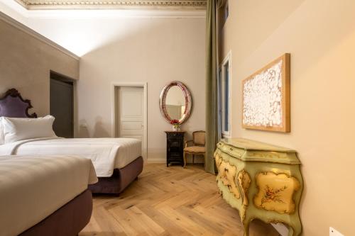 a bedroom with a bed and a mirror at Palazzo Doni by Florence Art Apartments in Florence