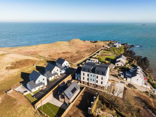 an aerial view of a house and the ocean at Tai Porth Llechog Townhouse By Birch Stays in Amlwch