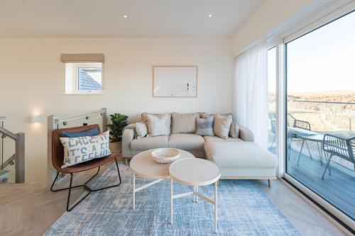a living room with a couch and a table at Tai Porth Llechog Townhouse By Birch Stays in Amlwch