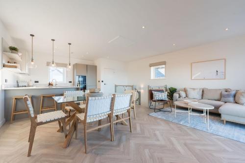 a kitchen and living room with a table and chairs at Tai Porth Llechog Townhouse By Birch Stays in Amlwch