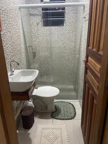 een badkamer met een douche, een toilet en een wastafel bij Casa da Jessica in Paraty