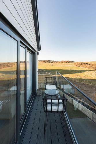 a balcony of a house with a chair on it at Tai Porth Llechog Townhouse By Birch Stays in Amlwch