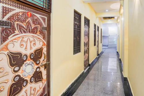 a hallway with a door with paintings on the wall at Pradhan Hotel in Prayagraj