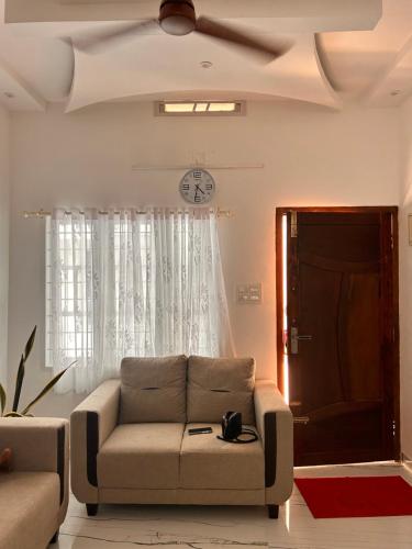 a living room with a couch and a clock on the ceiling at Cozy Haven Homestay Fort Kochi in Cochin