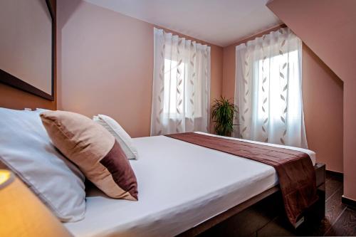 1 dormitorio con 1 cama grande y 2 ventanas en Apartments Casa Đekić, en Rovinj