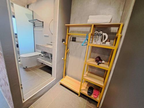 a bathroom with a shower and a yellow shelf at Chunfang Residence in Fangliao
