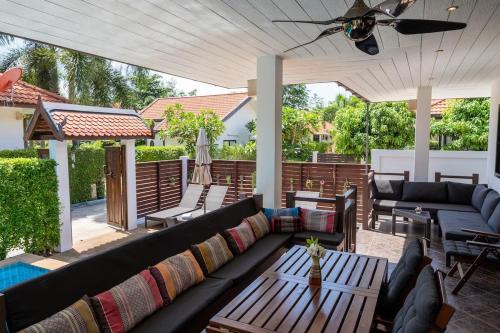 eine Terrasse mit einer Couch und einem Tisch in der Unterkunft Family friendly villa in Phra Ae beach
