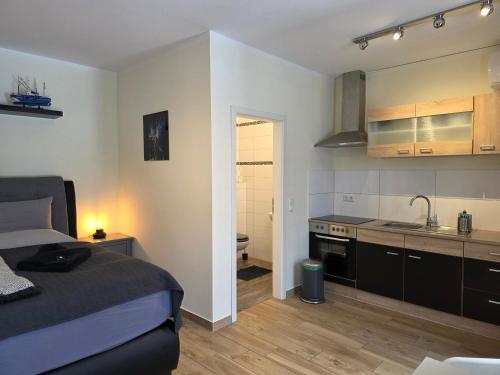 a small bedroom with a bed and a kitchen at Papageiennest in Dresden