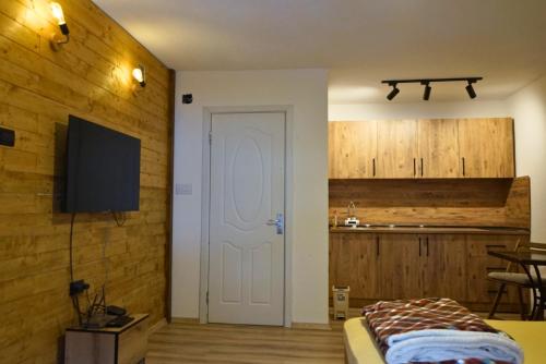 a bedroom with a white door and a kitchen at Korja Apartments Mavrovo in Mavrovo
