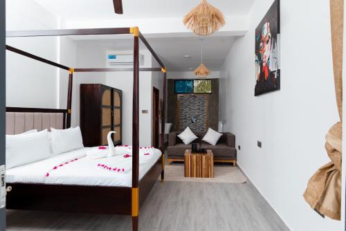 a bedroom with a bed and a couch in a room at Leparadis Zanzibar Boutique Hotel in Jambiani