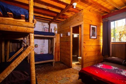 a bedroom with bunk beds in a wooden cabin at Mística Suítes in São Thomé das Letras