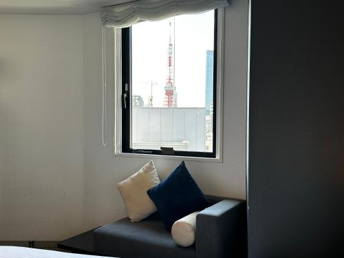 a room with a blue couch and a window at Henn na Hotel Tokyo Hamamatsucho in Tokyo