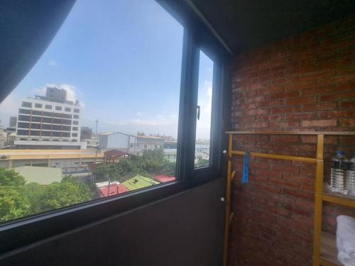 a window in a room with a view of a city at Chunfang Residence in Fangliao