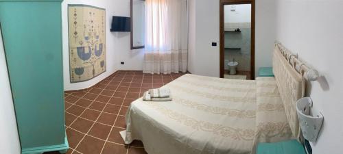 a bedroom with a bed and a tiled floor at Domo Rosada in Ottava Sassari