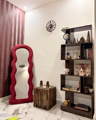 a living room with a red chair and a mirror at 3BHK apartment with the terrace in Gurgaon