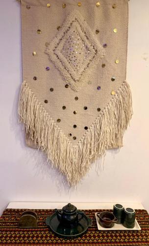 a blanket hanging on a wall next to a table at 3BHK apartment with the terrace in Gurgaon