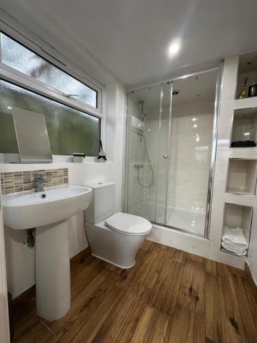 a bathroom with a toilet and a sink and a shower at Garden Studio Escape Open-Plan Comfort & Outdoor Space in London