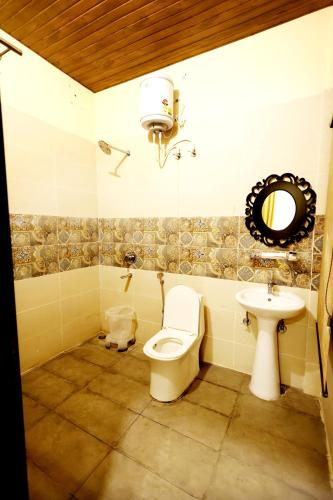 a bathroom with a toilet and a sink at Hari Mahal Resort in Behror