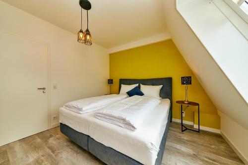 a bedroom with a bed with a yellow wall at Rochter Landhotel in Zeltingen-Rachtig