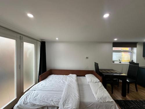 a bedroom with a bed and a desk and a window at Garden Studio Escape Open-Plan Comfort & Outdoor Space in London
