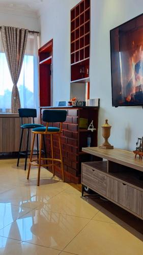 sala de estar con 2 taburetes y TV de pantalla plana en Munyonyo Penthouse, en Kampala