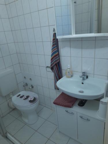 a white bathroom with a toilet and a sink at 2 Raum Wohnung in der Nähe des August Horch Museum in Zwickau