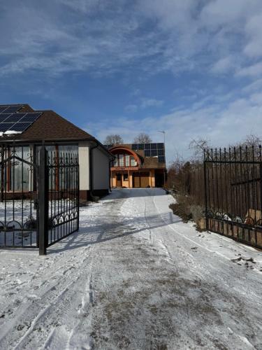 a driveway with a gate in front of a house at Prie Upės in Žagarė
