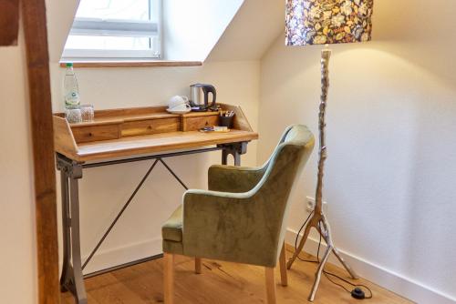 a desk with a chair and a lamp in a room at Rochter Landhotel in Zeltingen-Rachtig