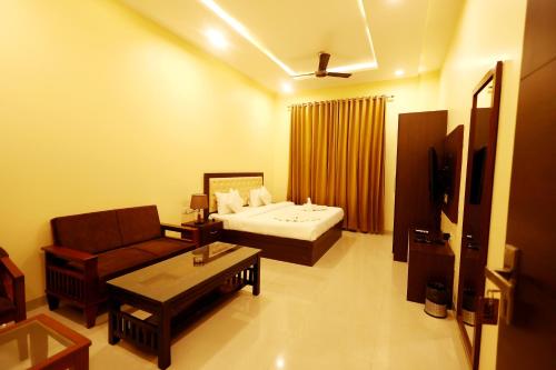 una habitación de hotel con una cama y un sofá en Hari Mahal Resort, en Behror
