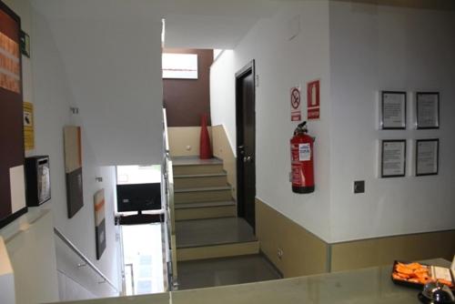 a hallway with a fire extinguisher on the wall at Hostal Central in Ceuta