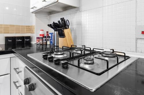 a stove top oven in a kitchen with a counter at Watford Cozy Full Home - Perfect for Harry Potter Studios! in Watford