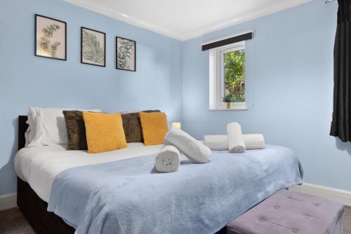 a bedroom with a large bed with blue walls at Watford Cozy Full Home - Perfect for Harry Potter Studios! in Watford